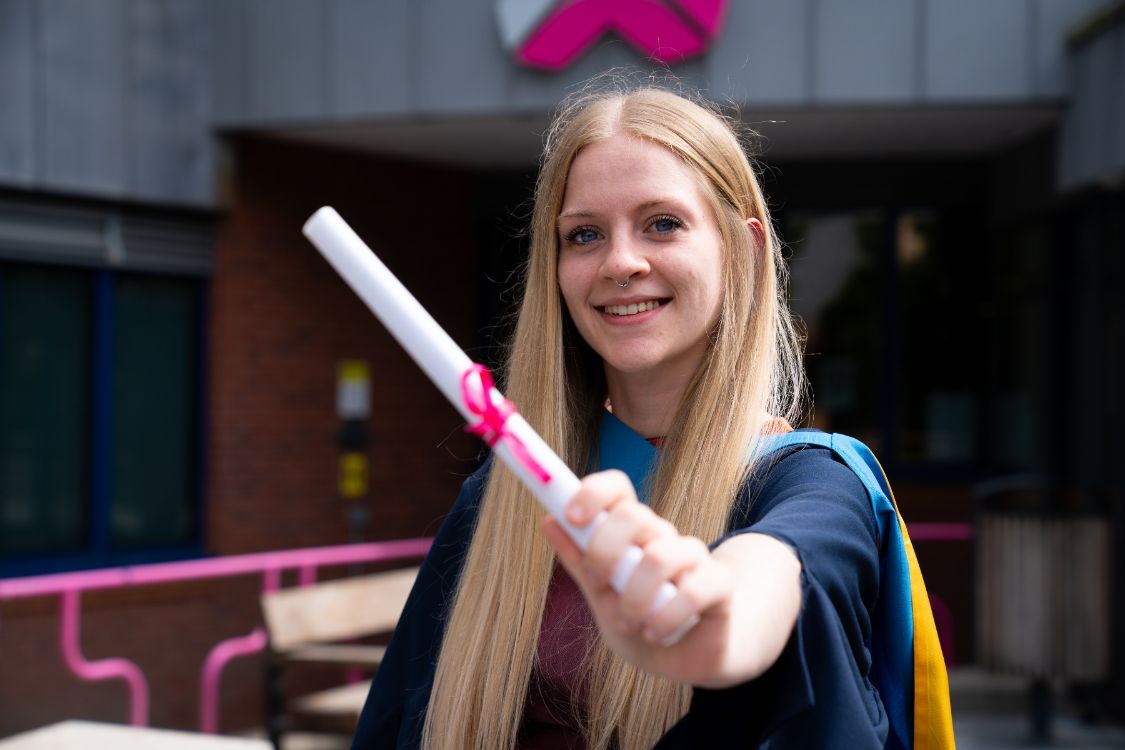 Image of graduate holding a scroll